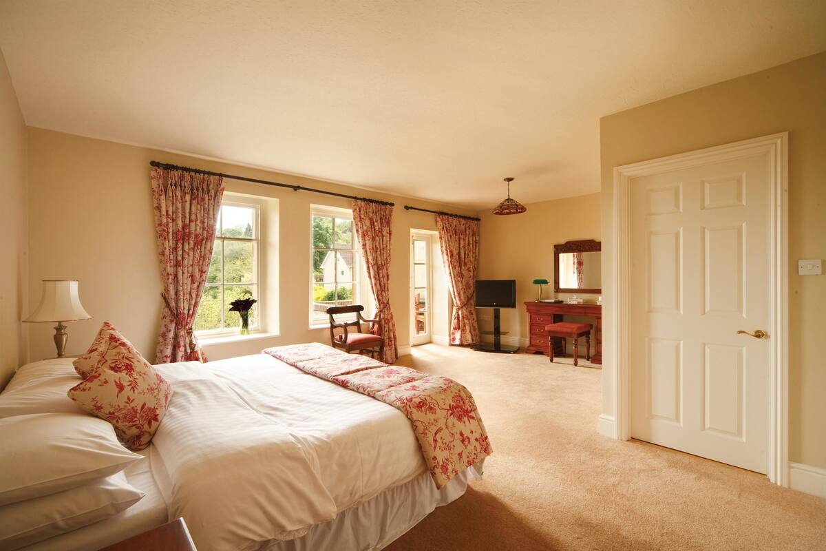 Une chambre avec un grand lit, un bureau et une chaise.