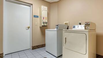 A laundry room with a door, a washing machine, and a dryer.