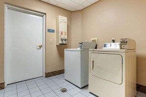 Une buanderie avec une porte, un lave-linge et un sèche-linge.