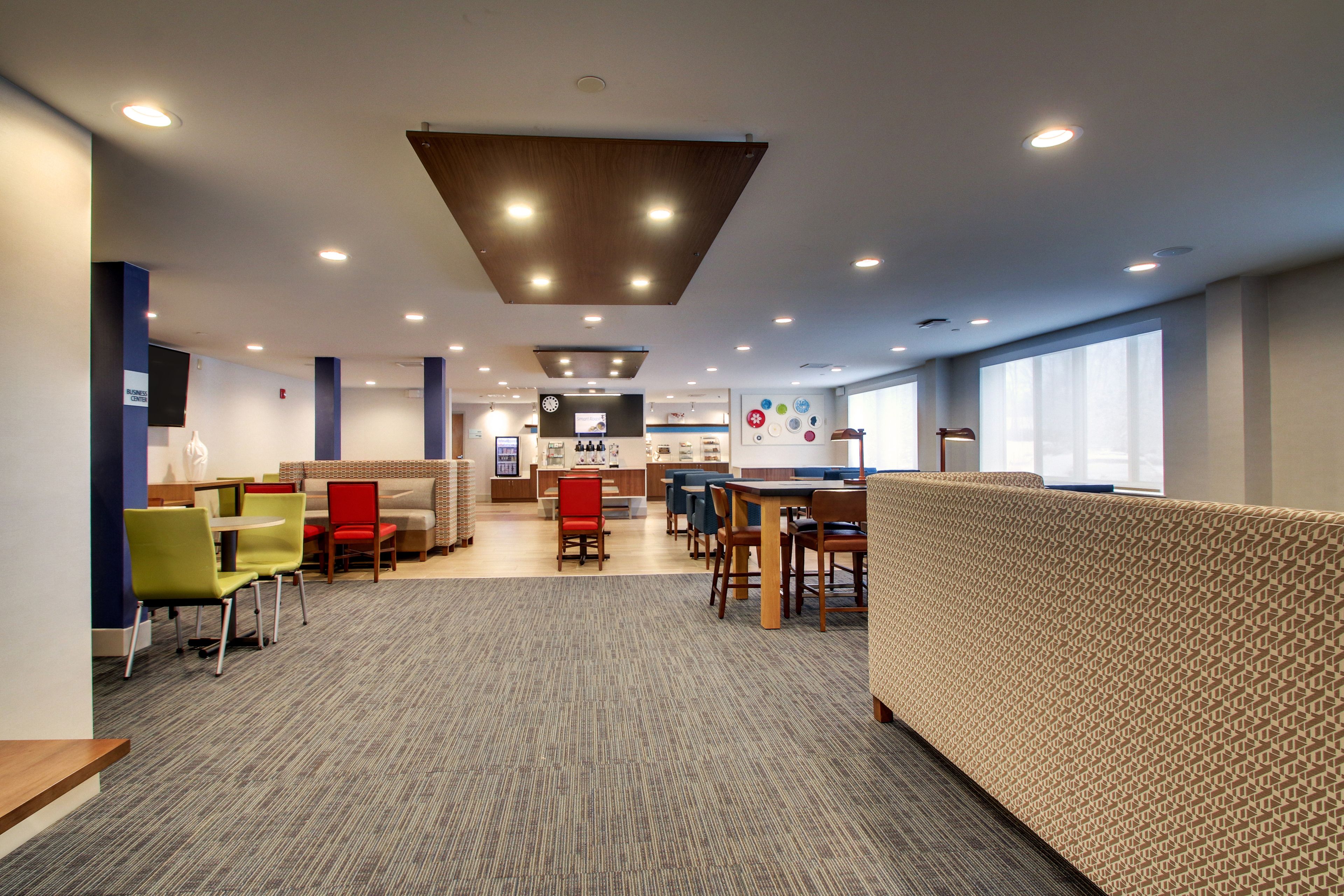 A modern, well-lit indoor space with seating areas, a counter, and a patterned wall.