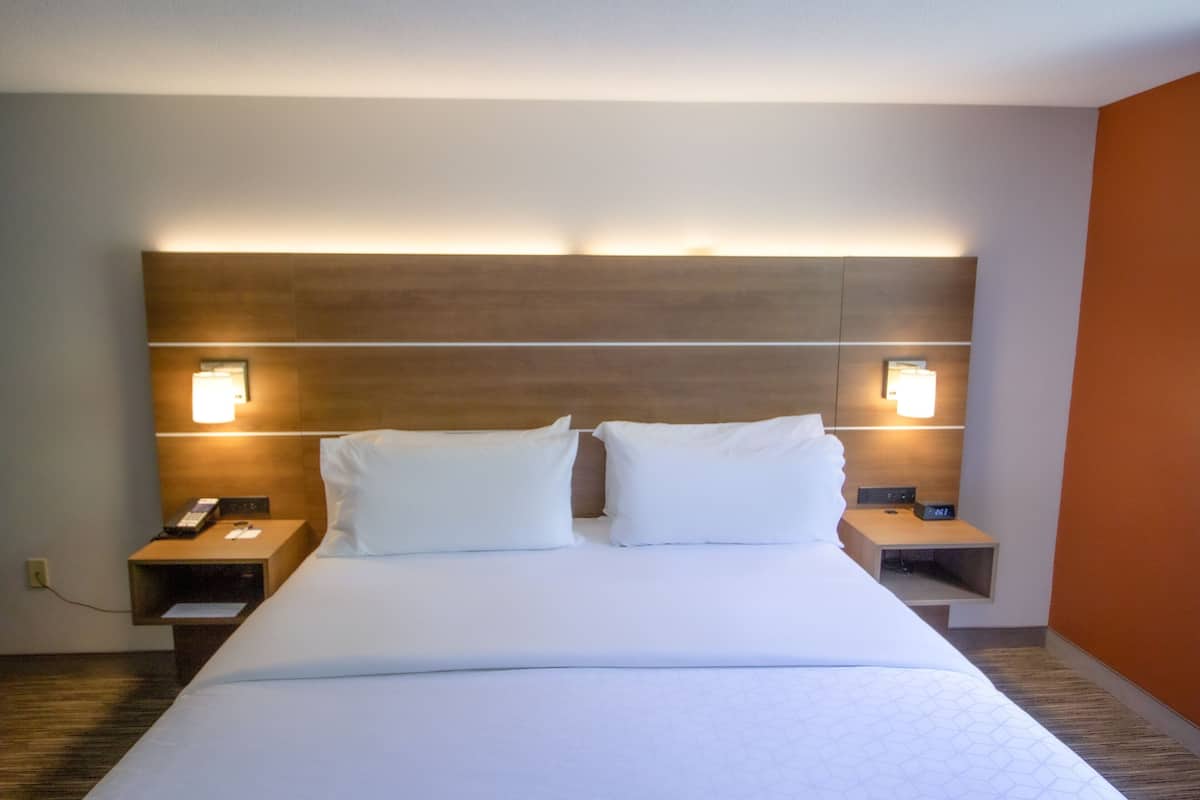 Ein Hotelzimmer mit einem großen Bett, zwei Nachttischen und Wandlampen.