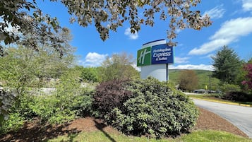 Ein Holiday Inn Express Schild, umgeben von viel Grün und blauem Himmel.
