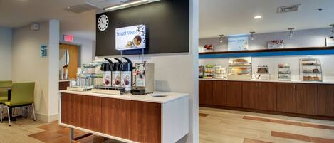 Een modern café met een koffiehoek, een klok en een bord met 'Smart Roast'.