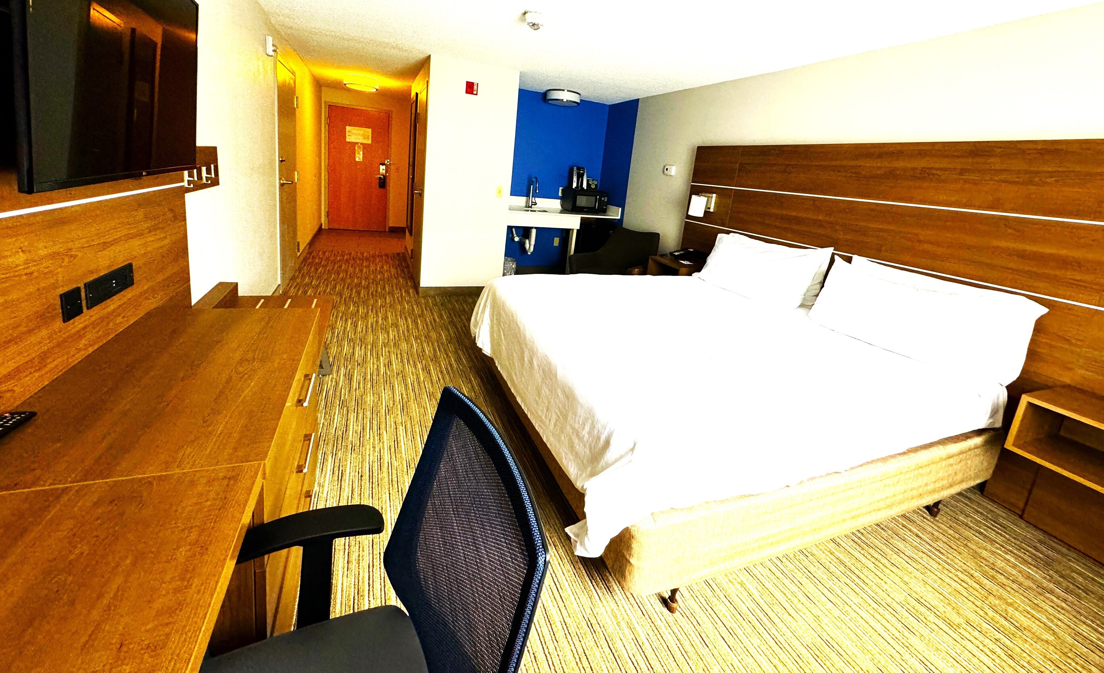 Une chambre d’hôtel équipée d’un lit, d’un bureau, d’une chaise et d’un téléviseur.