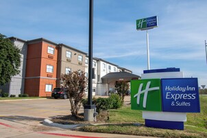 Señal de Holiday Inn Express & Suites, con una vista clara del edificio al fondo.
