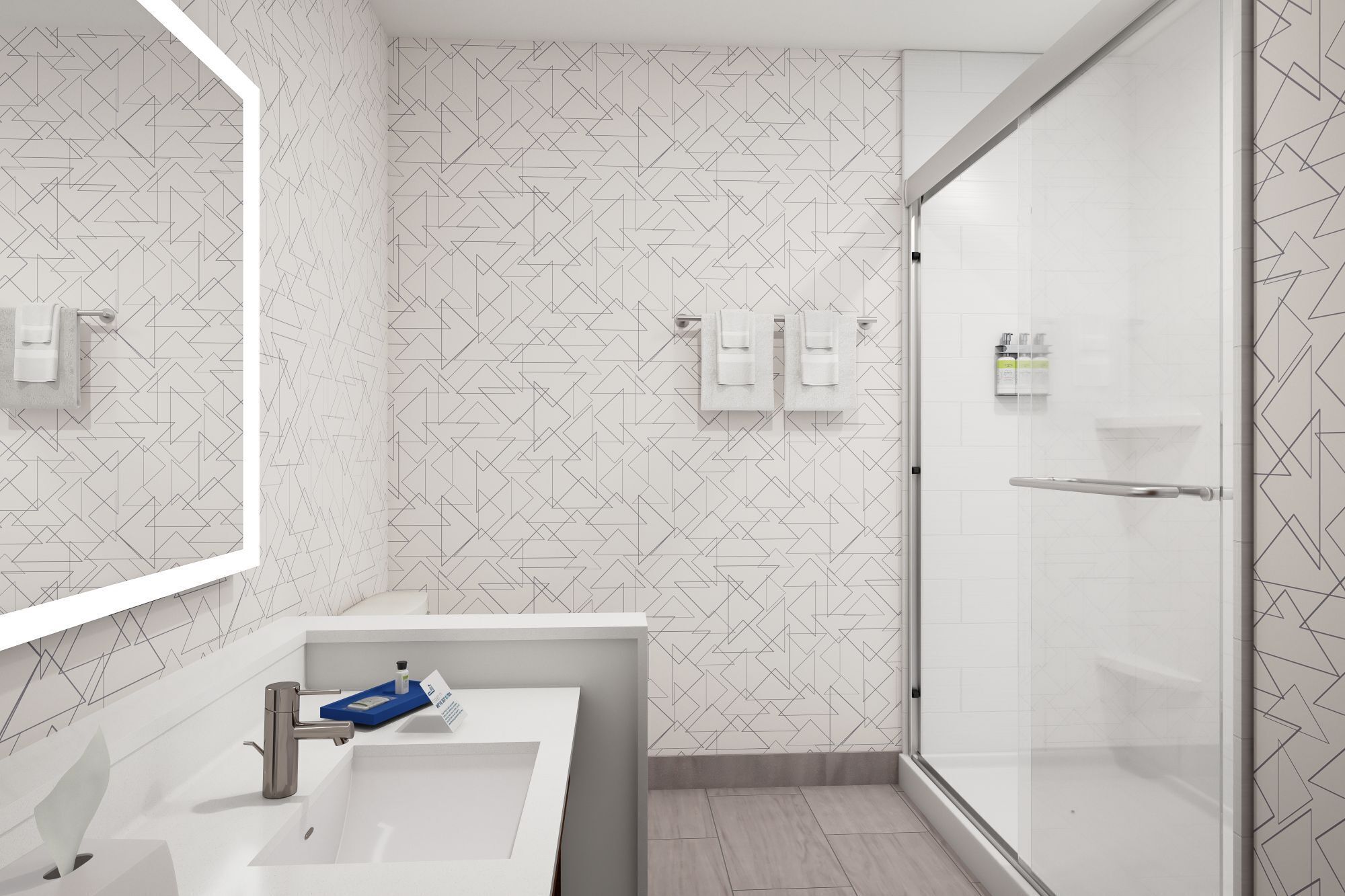 A modern bathroom with a geometric patterned wall, a glass shower enclosure, and a white sink with a towel rack.