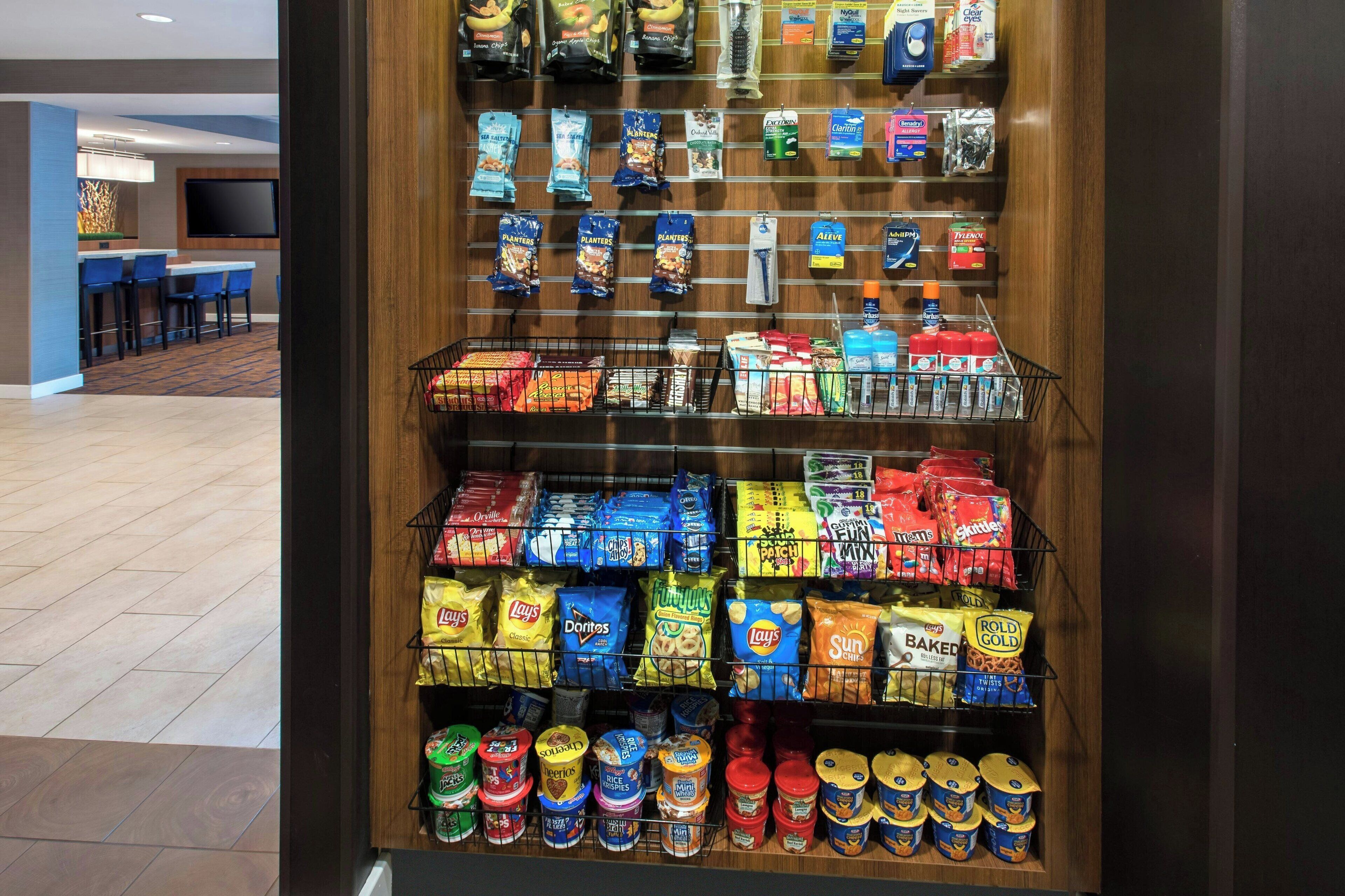 Een etalage met verschillende merken en soorten chips, snacks en conserven.