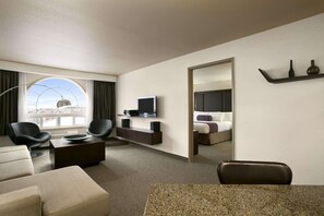 Enjoy a city view from the large window, with a flat-screen TV, comfortable sofa, and dining area.