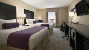 A hotel room with two beds, a desk, a chair, a television, and a window with a view. - Days Inn by Wyndham Regina (Regina)