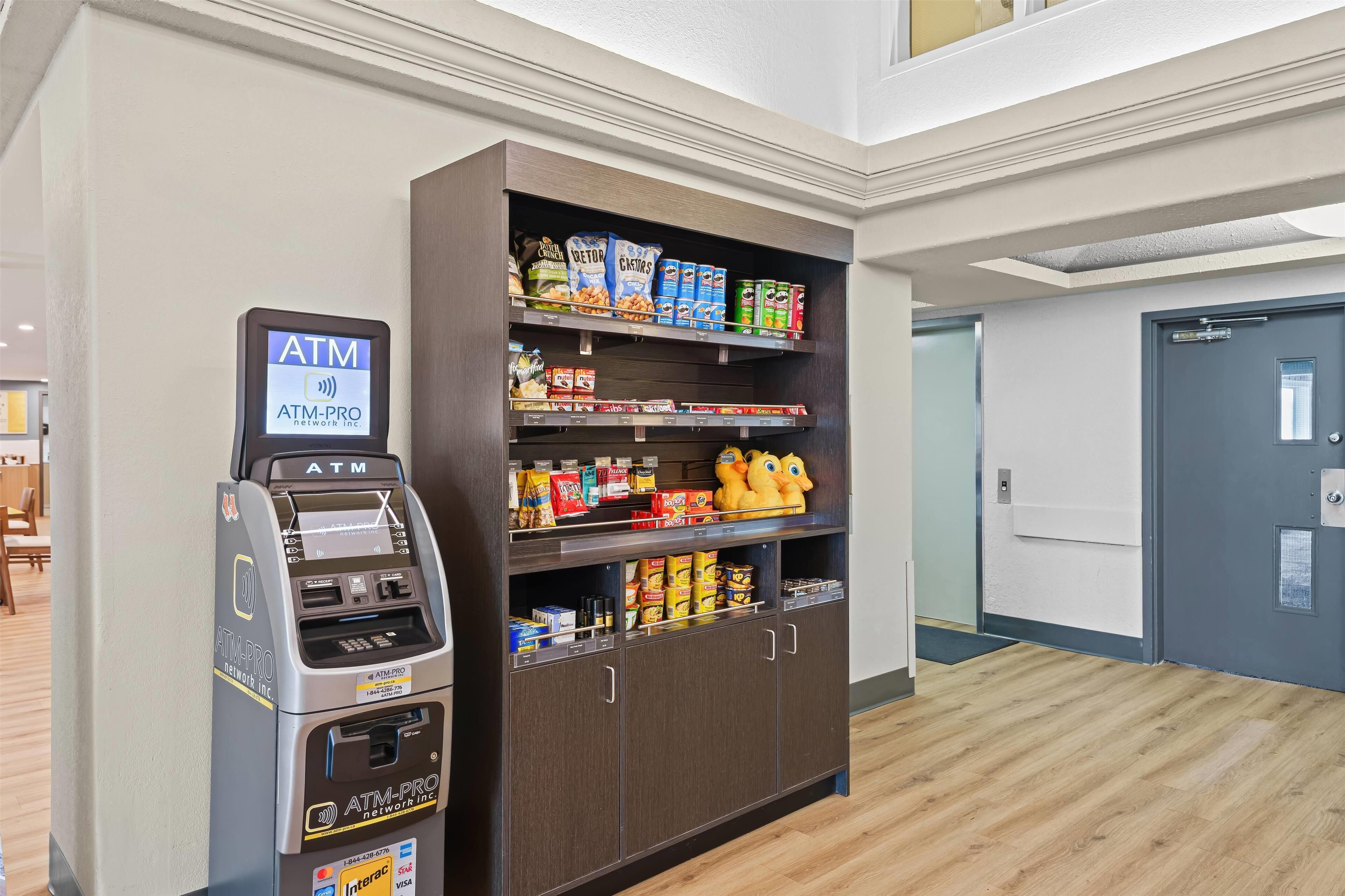 Ein Geldautomat und ein Getränkeautomat mit Snacks und Getränken in der Hotelhalle.