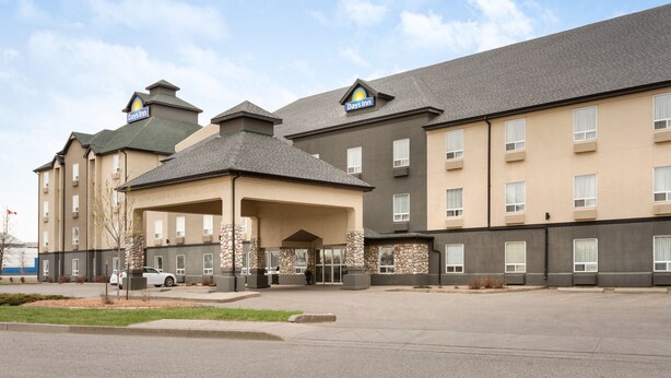 A Days Inn hotel with a two-story building, a covered entrance, and a parking lot. - Days Inn by Wyndham Regina (Regina)