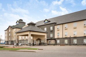 A Days Inn hotel with a two-story building, a covered entrance, and a parking lot. - Days Inn by Wyndham Regina (Regina)