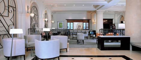 A lobby with a bar area, seating, and a patterned floor.