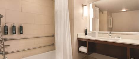 Une salle de bain moderne équipée d’une baignoire, d’une douche et d’un meuble-lavabo avec un miroir.