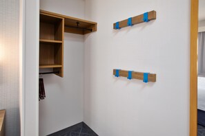 A room with a wooden wardrobe, a coat rack, and two wall-mounted hooks. - Hampton Inn Hotel Detroit/Belleville-Airport Area (Belleville)