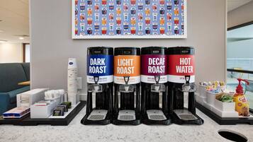 A coffee station with four dispensers labeled DARK ROAST, LIGHT ROAST, DECAF ROAST, and HOT WATER.