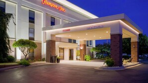 Ett Hampton Inn-hotell med en välkomnande skylt, en överbyggd entré och en tydlig uppfart.