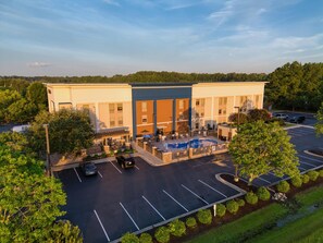 A hotel with a swimming pool, outdoor seating, and a parking lot. - Hampton Inn Edenton (Edenton)