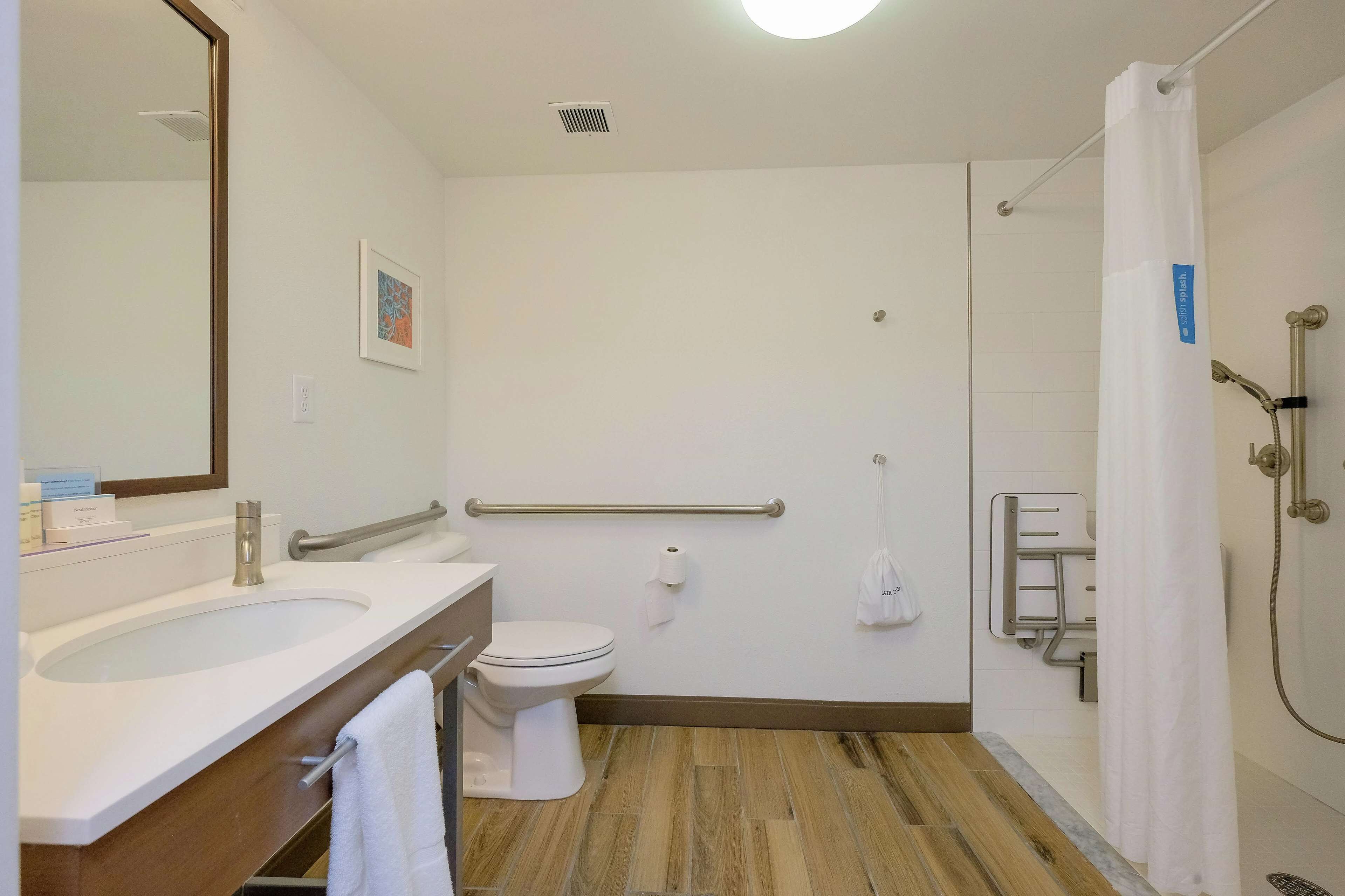 A modern bathroom with a sink, toilet, and shower.
