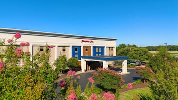 A Hampton Inn with a parking lot and surrounding greenery.