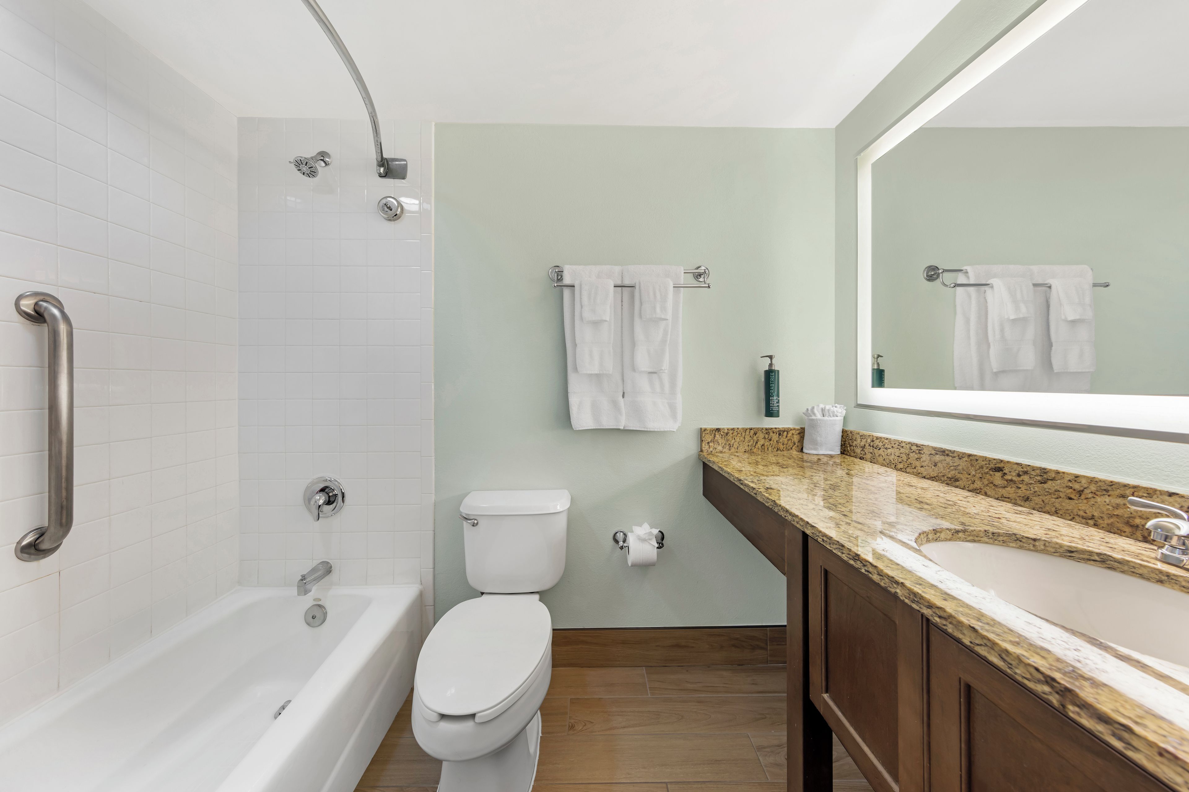 A bathroom with a bathtub, toilet, and sink.