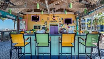 A bar area with a wooden ceiling, bar stools, and a counter.