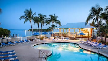 Alberca al aire libre, sombrillas en la alberca y camastros