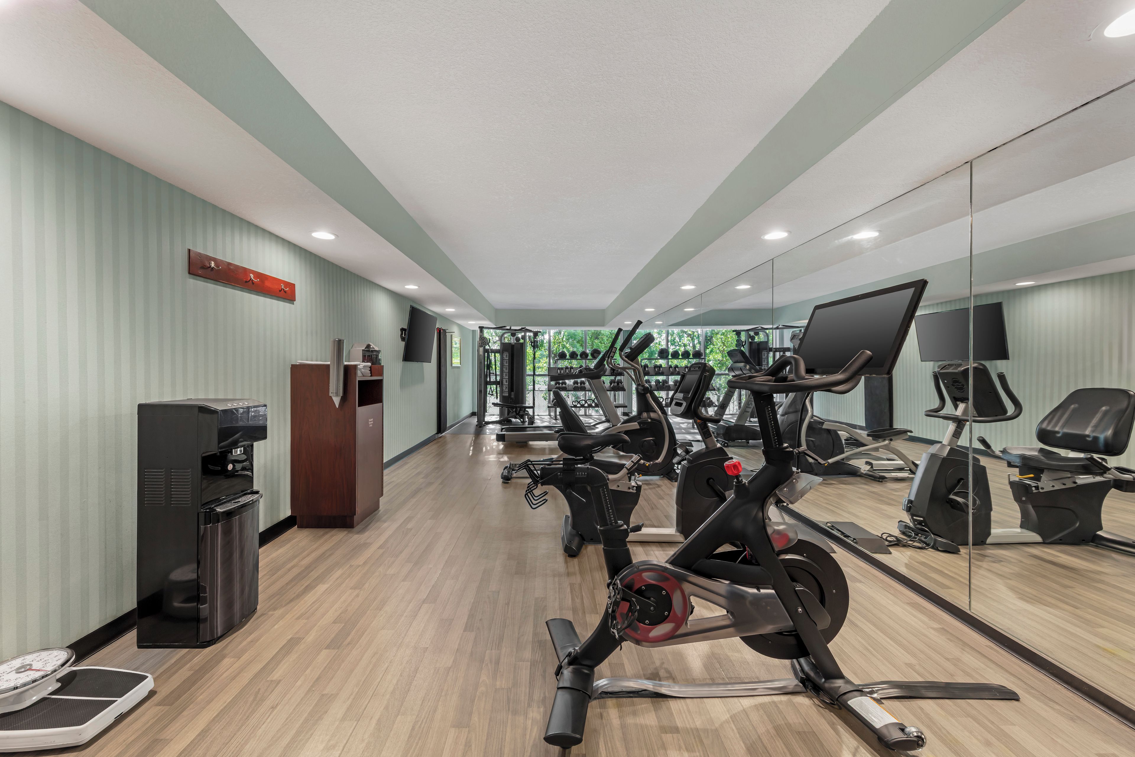 A gym with exercise equipment, a water dispenser, and a scale.