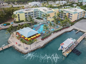 A resort with a swimming pool, a dock, and a building with multiple balconies. - Bluegreen Vacations Hammocks at Marathon, Ascend Collection Resort (Marathon)