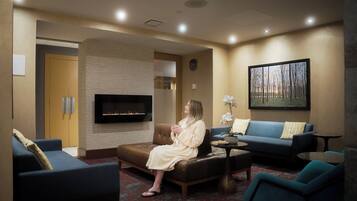 A modern living room with a fireplace, sofas, and a television.