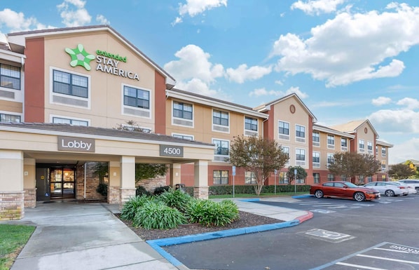A hotel with a 'Lobby' entrance, a '4500' address sign, and a parking lot with cars.