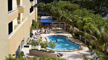 Una piscina al aire libre, sillones reclinables de piscina