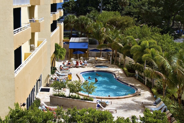 Una piscina al aire libre, sillones reclinables de piscina