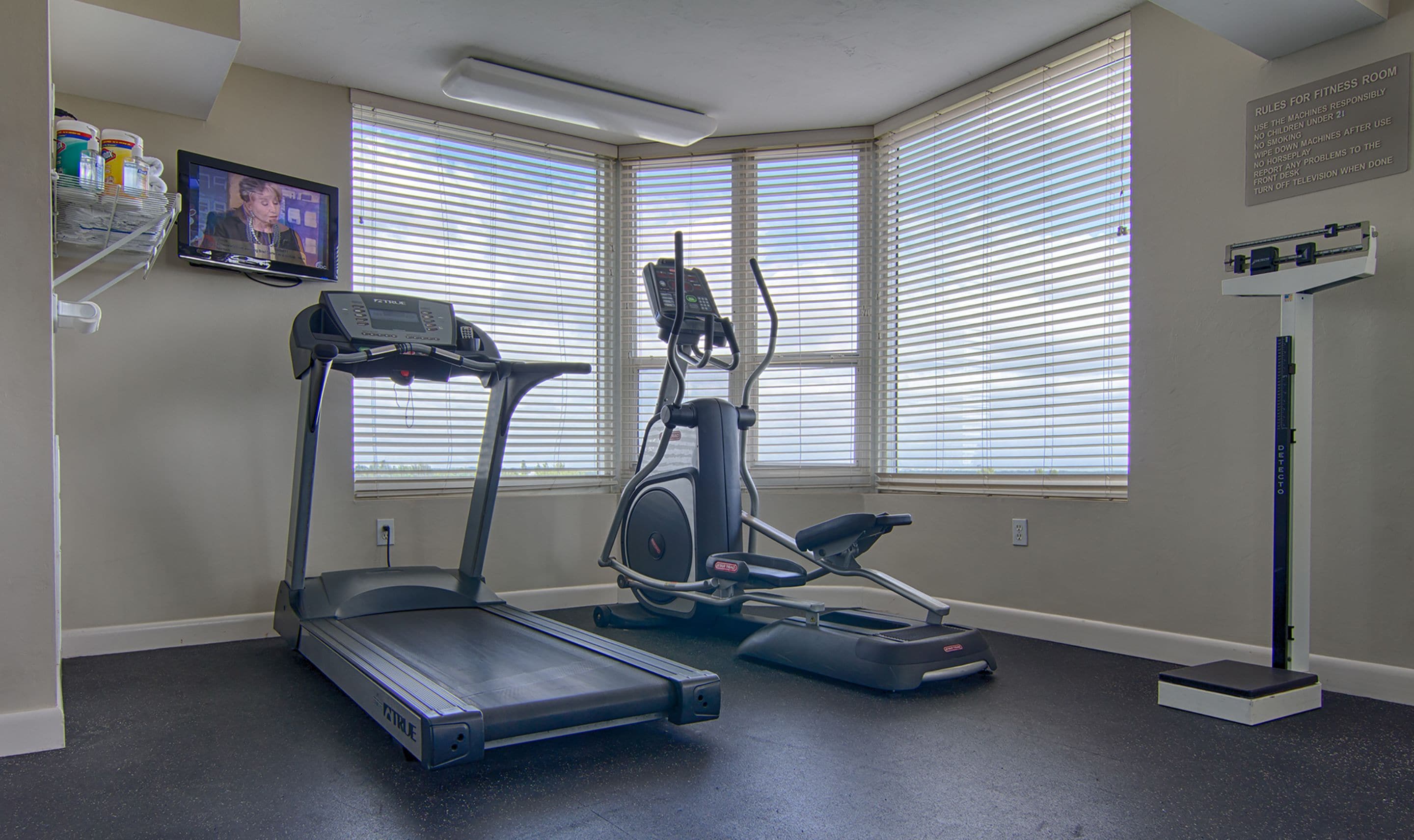 A fitness room with a treadmill, elliptical, and stationary bike.