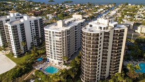 A high-rise hotel with multiple floors, a rooftop pool, and a marina in the background. - GullWing Beach Resort (Fort Myers Beach)