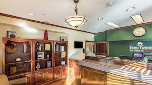 A reception area with a wooden reception desk, a clock, and a wall sign for 'HOMETOWN STUDIOS'.