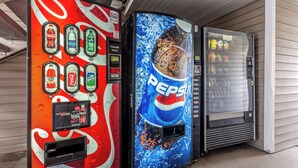 Two beverage vending machines, one with Coca-Cola and the other with Pepsi branding, next to a building. - HomeTowne Studios by Red Roof Atlanta - Chamblee (Chamblee)