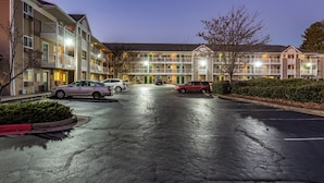 A multi-story hotel with a parking lot in front.