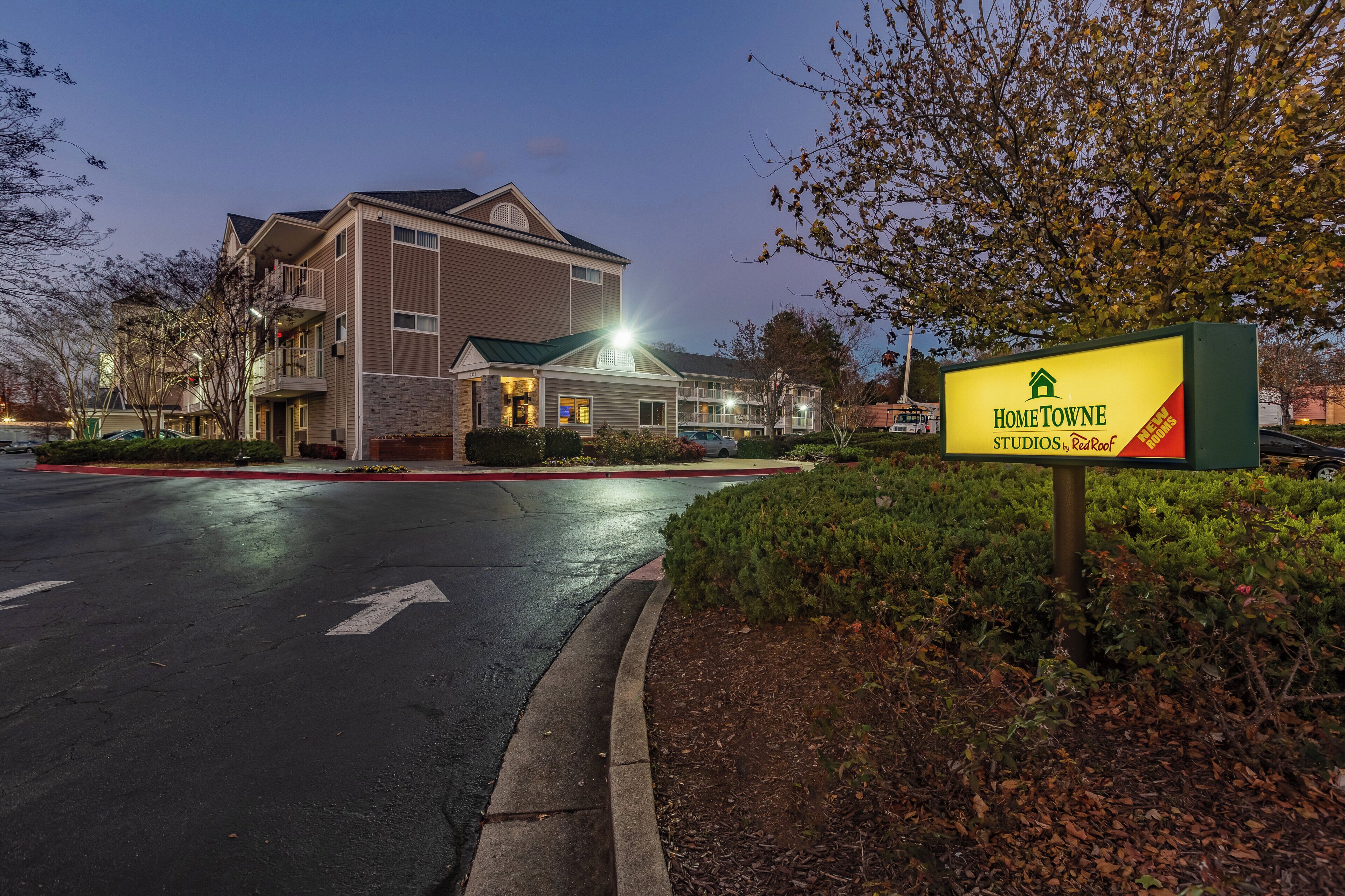 A multi-story building with a sign for 'HomeTowe Studios by RedRoof' indicating new rooms.