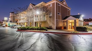 A multi-story hotel with a parking lot in front.