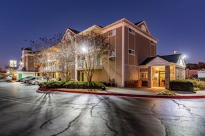 A multi-story hotel with a parking lot in front. - HomeTowne Studios by Red Roof Atlanta - Chamblee (Chamblee)