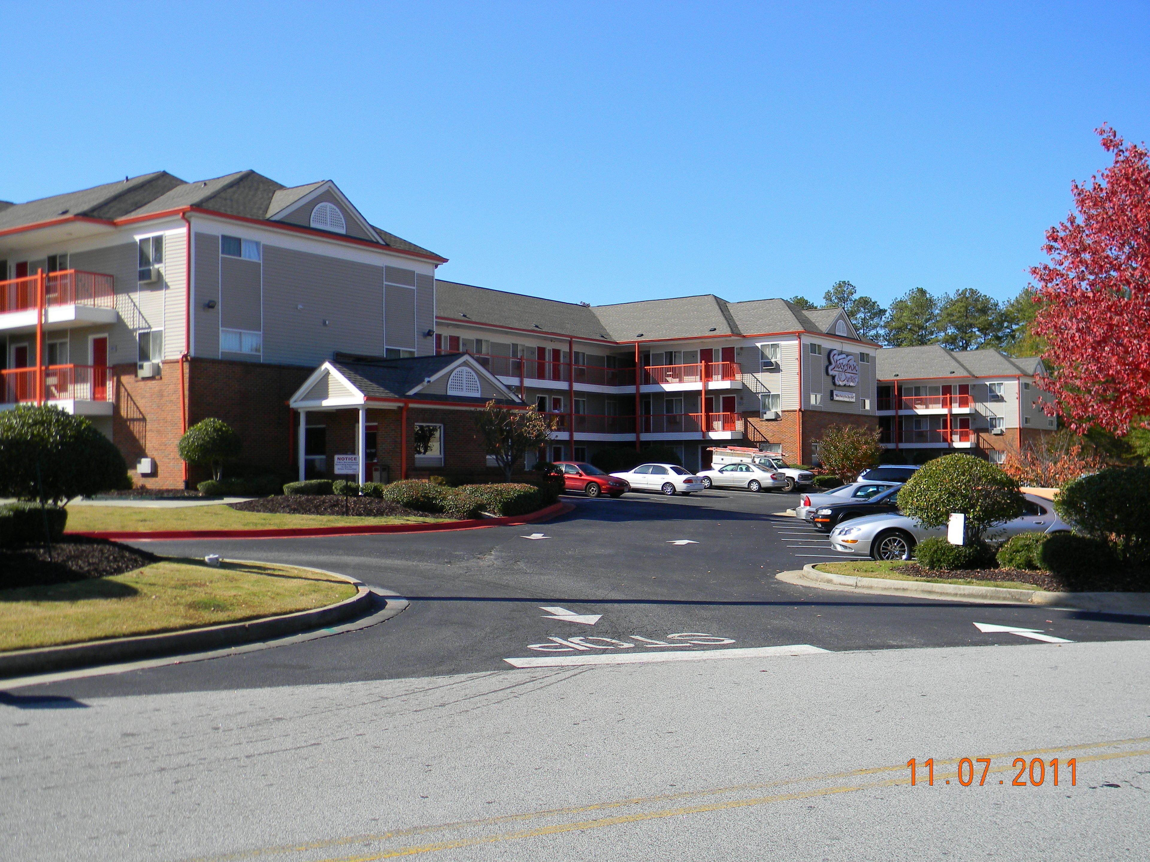 A multi-story hotel with a parking lot in front.