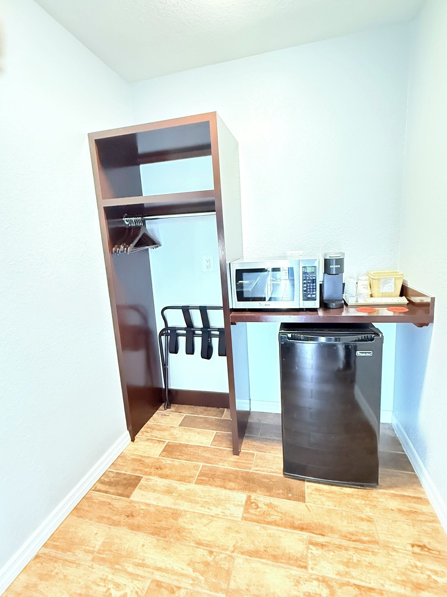 A compact kitchenette with a microwave, coffee maker, and a small refrigerator.