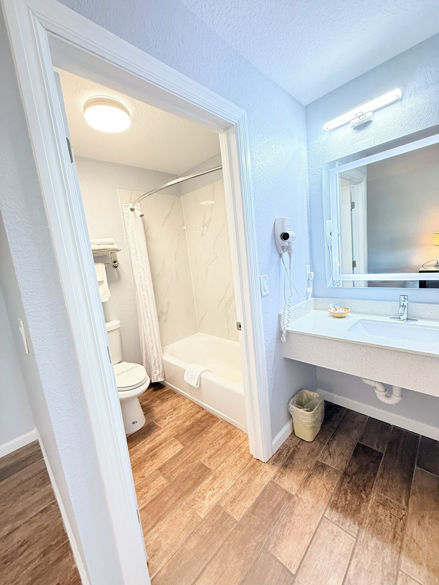 A bathroom with a shower, toilet, and bathtub.