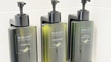 Drei Flaschen Mikado Boutique Essential Produkte: Shampoo, Conditioner und Hand- & Körperwaschgel.