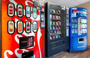 Máquina expendedora con el logotipo de Pepsi, máquina de Coca-Cola con diversas bebidas, y una máquina con el logotipo de Fanta.