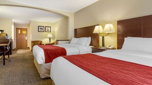 Ein Hotelzimmer mit zwei Betten, einem Schreibtisch und einem Stuhl.