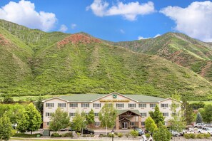 Un hotel con techo verde, múltiples ventanales y un letrero que dice 'GOLDEN INN & SUOFEN'.