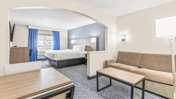 Ein Hotelzimmer mit Bett, Sofa, Schreibtisch und Fernseher.