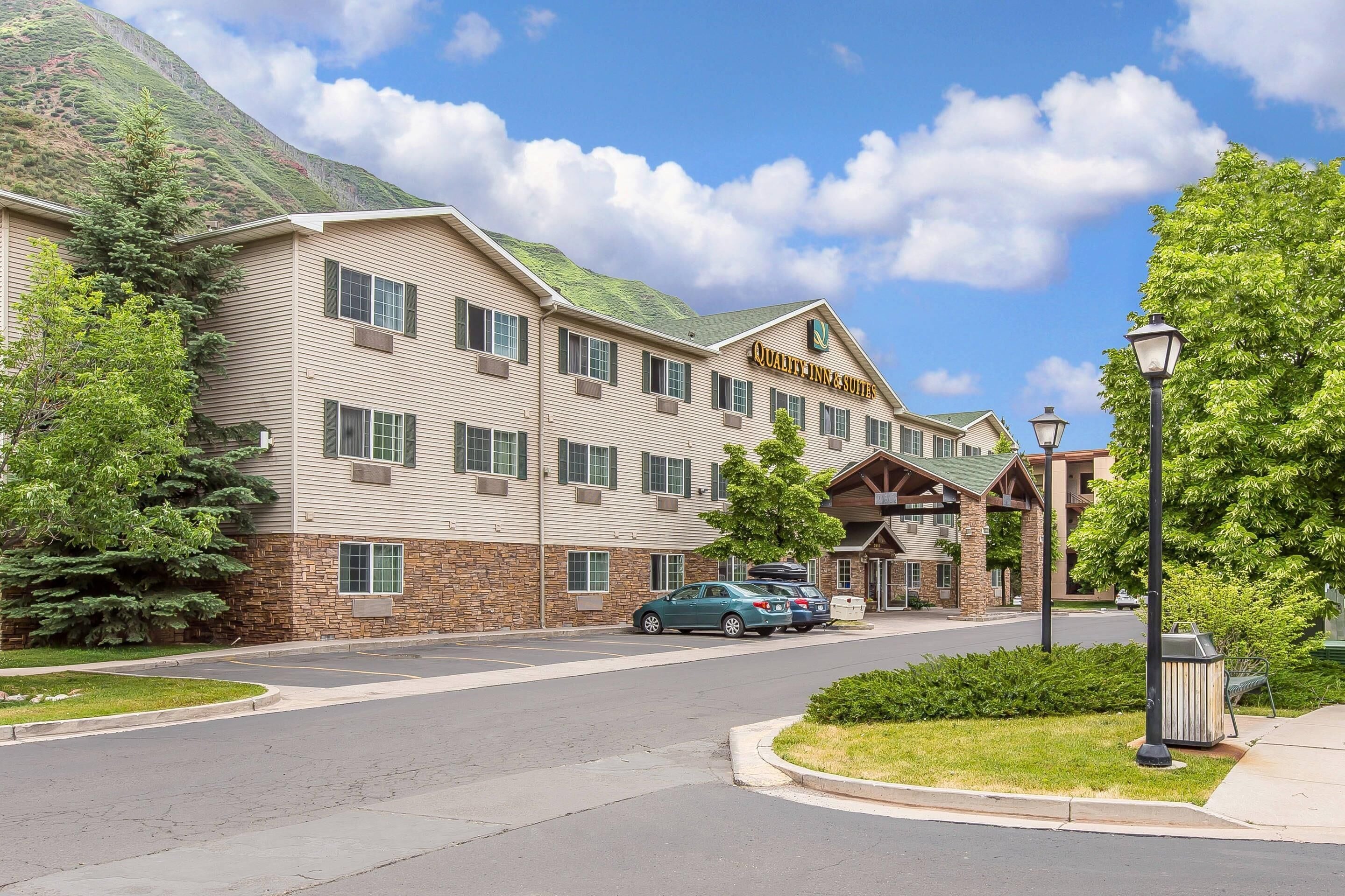 A hotel with a stone facade, multiple windows, and a sign reading "Quality Inn & Suites".